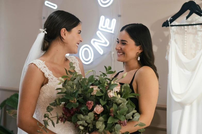 a couple of women standing next to each other, bouquets, jordan grimmer and natasha tan, never one - to - one, one is a brunette