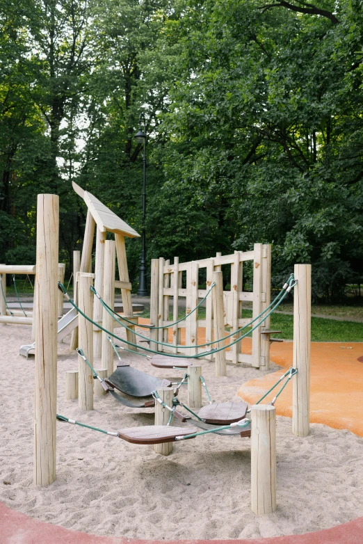 a playground in the middle of a park, inspired by Otakar Sedloň, unsplash, wooden supports, sandy beach, german forest, square