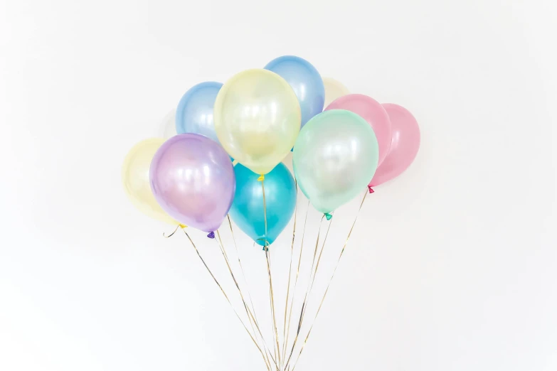 a bunch of balloons sitting on top of a table, a pastel, by Nicolette Macnamara, pexels, mother of pearl iridescent, set against a white background, high quality product photo, in colour