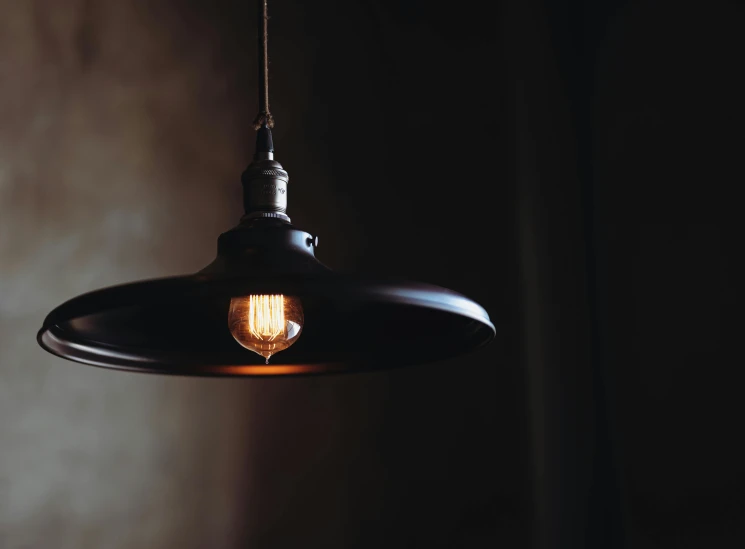 a light hanging from a ceiling in a dark room, pexels contest winner, soft warm light, instagram post, cafe lighting, with a black dark background