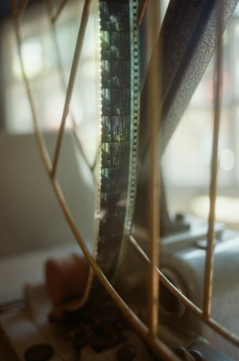 a fan sitting on top of a table next to a window, a picture, by Jessie Algie, unsplash, photorealism, super 8mm film, an extreme closeup shot, golden light film grain, close - up on detailed