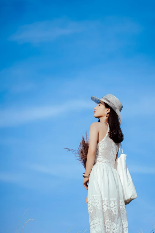 a woman in a white dress and hat standing in a field, by Tan Ting-pho, minimalism, cloudless blue sky, 5 0 0 px models, portait image, holiday