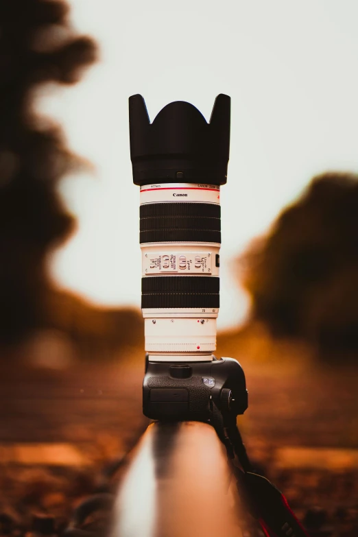 a camera sitting on top of a rail, by Adam Rex, unsplash contest winner, photorealism, canon- 70-200mm lens, towering over the camera, panoramic photography, toy photography