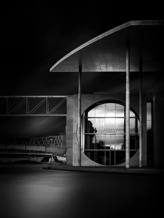 a black and white photo of a building at night, by Joze Ciuha, curved bridge, bus station, hasselblad photograph, full of glass. cgsociety