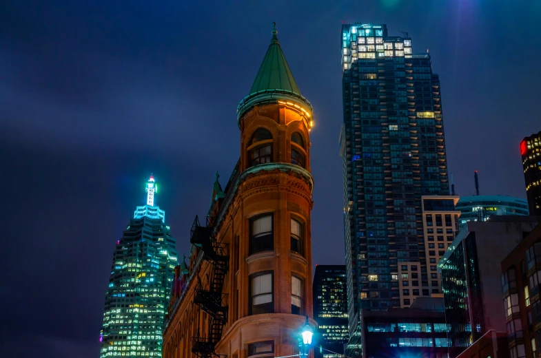 a very tall building sitting in the middle of a city, by Greg Rutkowski, pexels contest winner, art nouveau, vibrant lights, toronto, slide show, in a city with a rich history