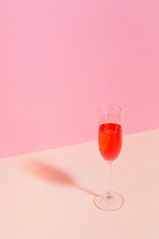 a glass of wine sitting on top of a table, by Cosmo Alexander, pexels contest winner, pink background, bubbly, but minimalist, drinking cocktail