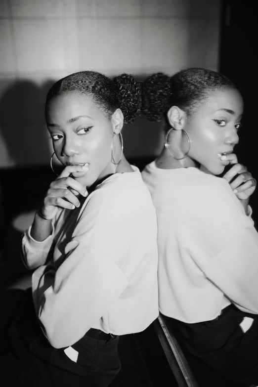 a black and white photo of two women brushing their teeth, a black and white photo, by Clifford Ross, unsplash, 9 0 s hip - hop fashion, beautiful gemini twins portrait, with dark hair tied up in a bun, photo of a black woman