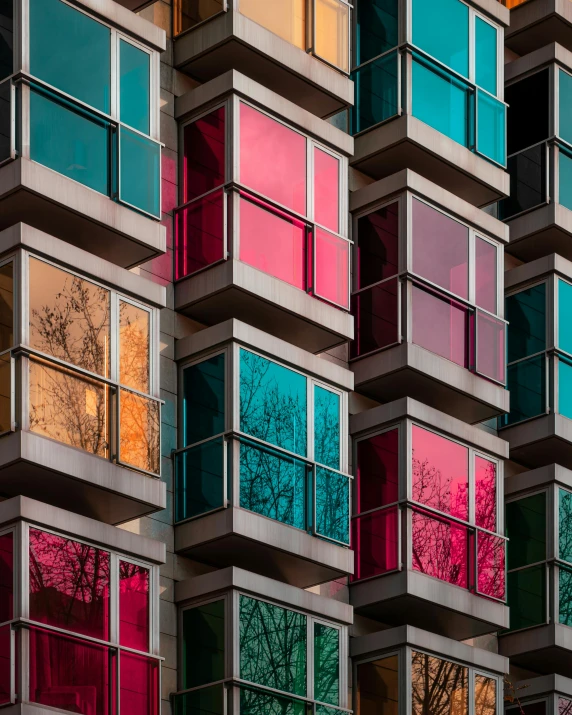 a multicolored building with lots of windows, inspired by Ricardo Bofill, unsplash contest winner, modular constructivism, with shiny glass buildings, taken in the late 2010s, glass panes, lgbtq