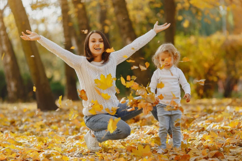 a woman and a child throwing leaves in the air, avatar image, professional image, trending photo, square