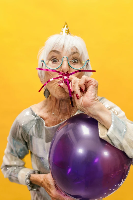 a woman holding a purple balloon in front of her face, a silver haired mad, wearing round glasses, high-quality photo, licking out