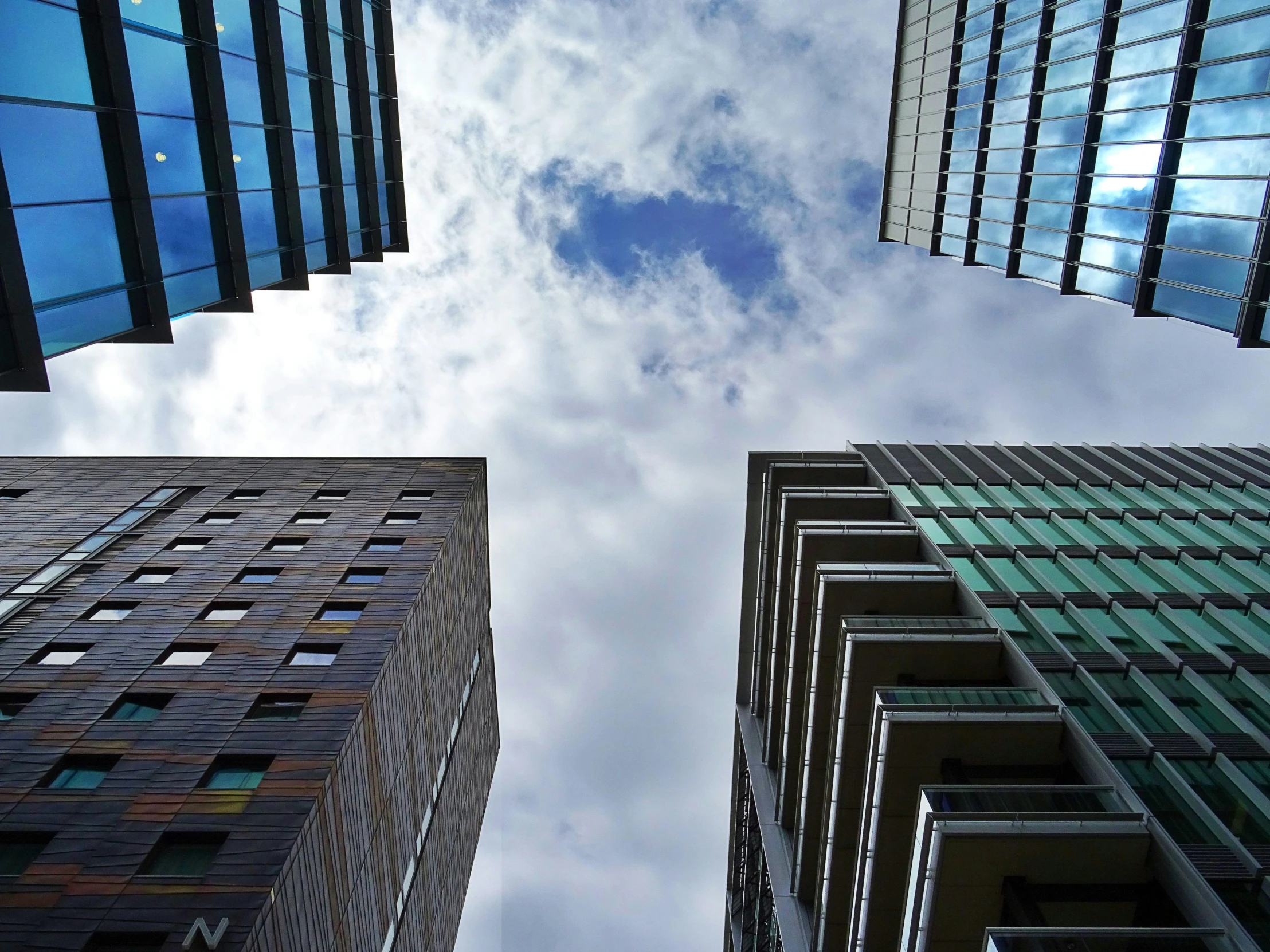 a group of tall buildings sitting next to each other, a picture, by Adam Rex, looking up onto the sky, manchester, multiple stories, floating buildings