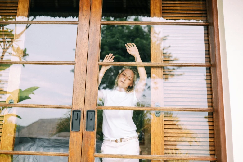 a woman standing in front of a wooden door, glass ceilings, having a great time, sydney sweeney, person made out of glass