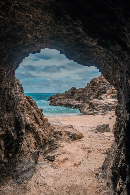 a view of the ocean from inside a cave, by Reuben Tam, unsplash contest winner, beach landscape, brown, australia, cornwall