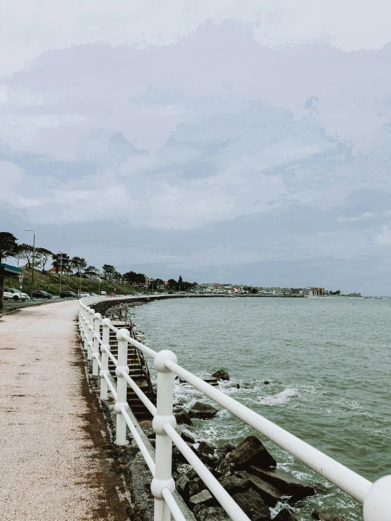 a man riding a bike down a sidewalk next to a body of water, at the sea, panoramic view, with walkways, gloomy skies