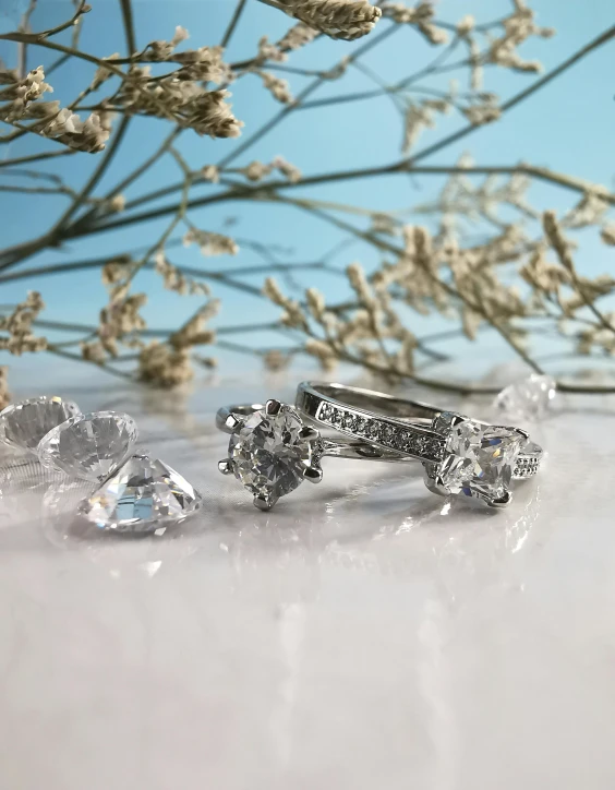 a couple of rings sitting on top of a table, large stones, thumbnail, a high angle shot, sparkle