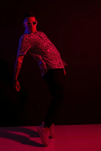 a man standing in front of a red light, patterned clothing, dynamic dance photography, dark. studio lighting, lil peep