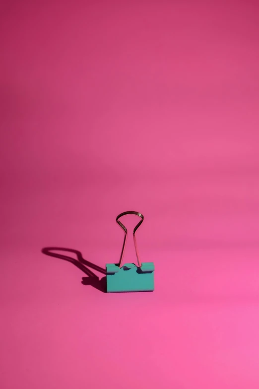a green binder sitting on top of a pink surface, by Peter Alexander Hay, pexels contest winner, postminimalism, clamp, cyan, shadows, digital image