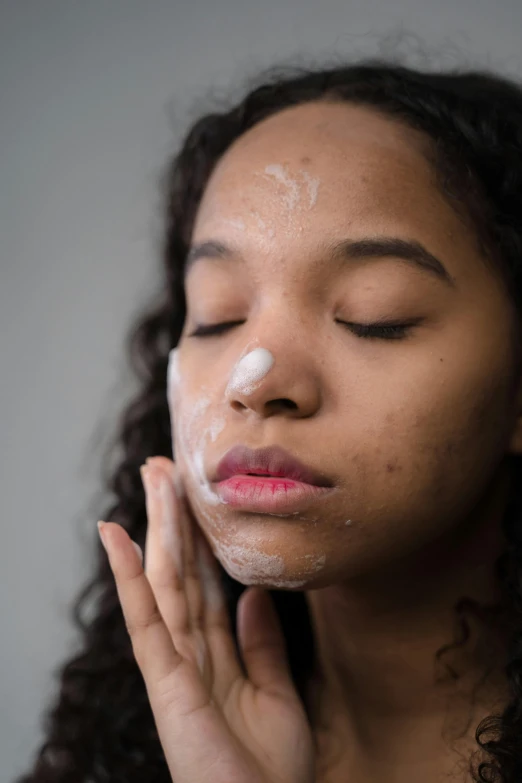 a woman with a lot of cream on her face, by Everett Warner, trending on pexels, renaissance, teenage girl, freezing, mixed-race woman, product shot