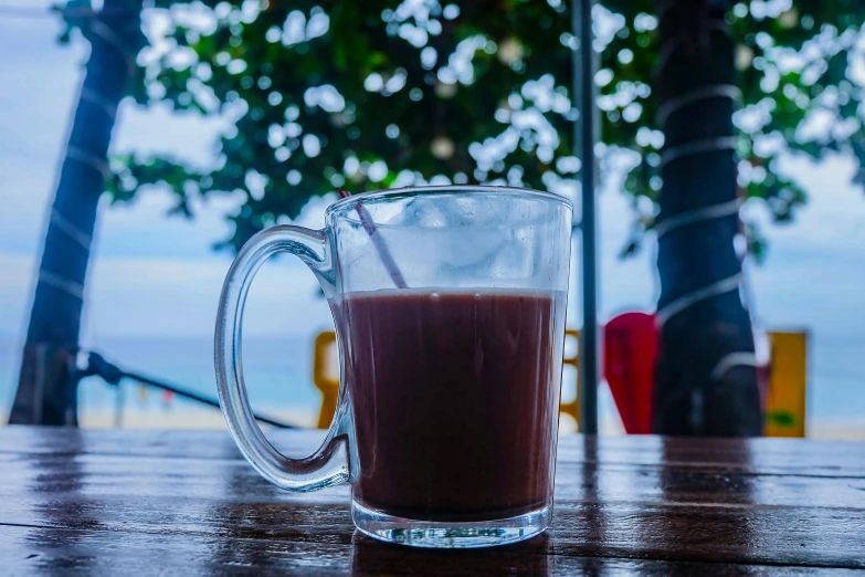 a cup of coffee sitting on top of a wooden table, by Daniel Lieske, pexels contest winner, sumatraism, maple syrup sea, avatar image