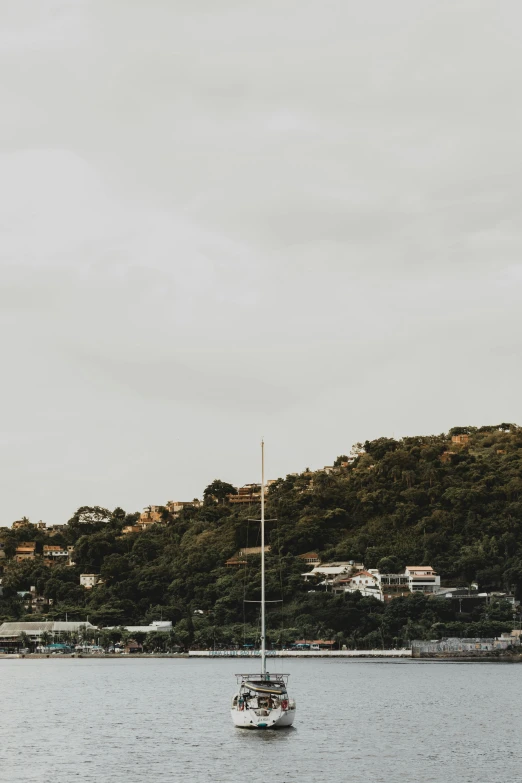 a couple of boats floating on top of a body of water, by Robbie Trevino, unsplash, city on a hillside, puerto rico, low quality grainy, three masts