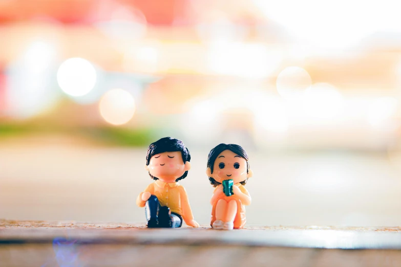 a couple of figurines sitting next to each other, a tilt shift photo, inspired by Nara Yoshitomo, unsplash, kenny wong x pop mart, early evening, brightly-lit, childhood friend