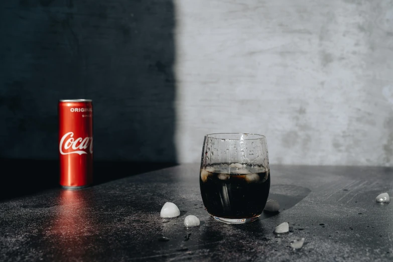 a coke can sitting next to a glass of coke, inspired by Elsa Bleda, pexels contest winner, dark and modern, mixing drinks, simple aesthetic, high resolution product photo