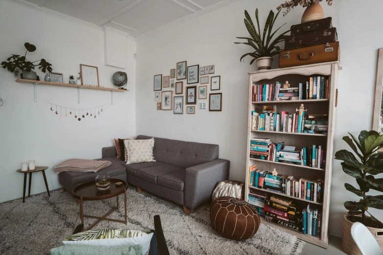 a living room filled with furniture and lots of books, unsplash contest winner, in chippendale sydney, white and teal metallic accents, office/thrift store/social hall, cottagecore hippie