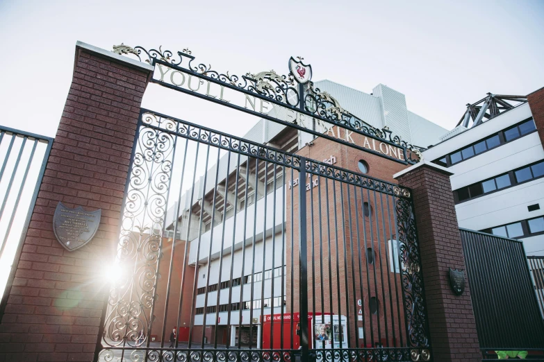 an iron gate in front of a brick building, a picture, unsplash, happening, liverpool football club, outside the simulation, 💋 💄 👠 👗, private academy entrance