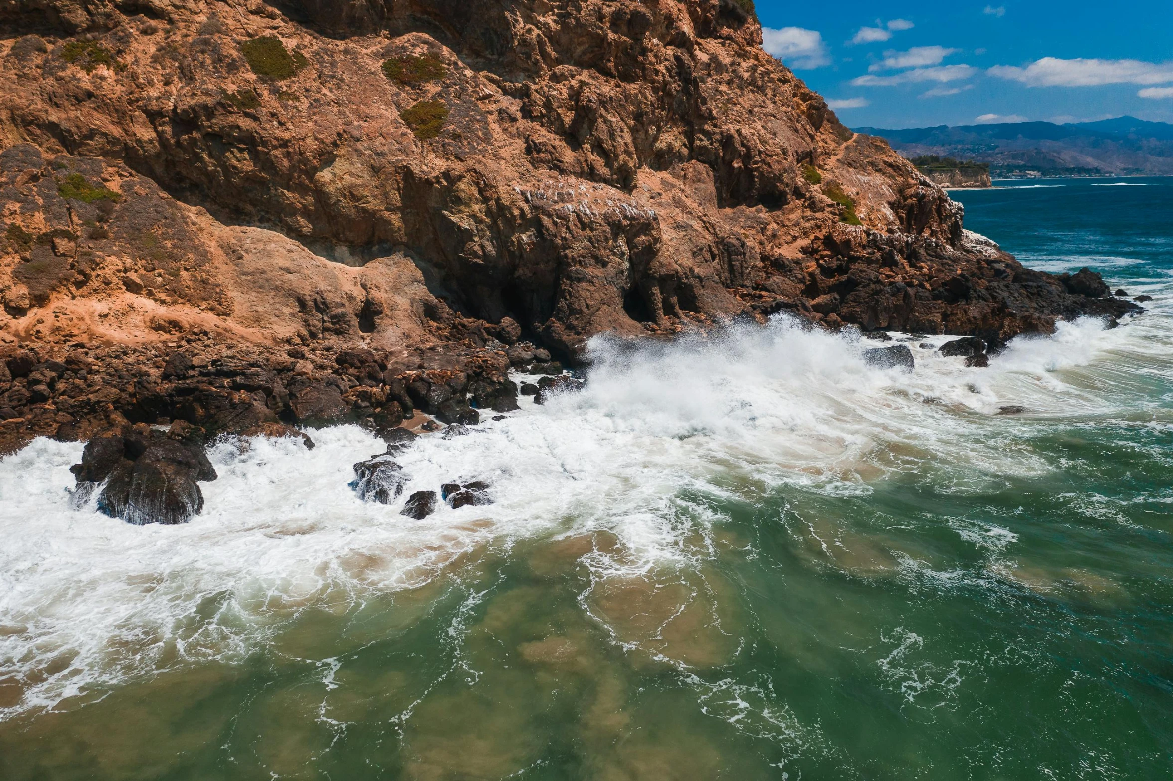 a large body of water next to a rocky cliff, pexels contest winner, waves and splashes, hollister ranch, scylla and charybdis, brown