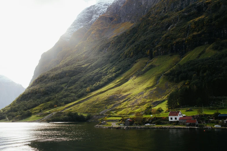 a body of water with a mountain in the background, by Jesper Knudsen, pexels contest winner, hurufiyya, idyllic cottage, hillside, incredible light, conde nast traveler photo