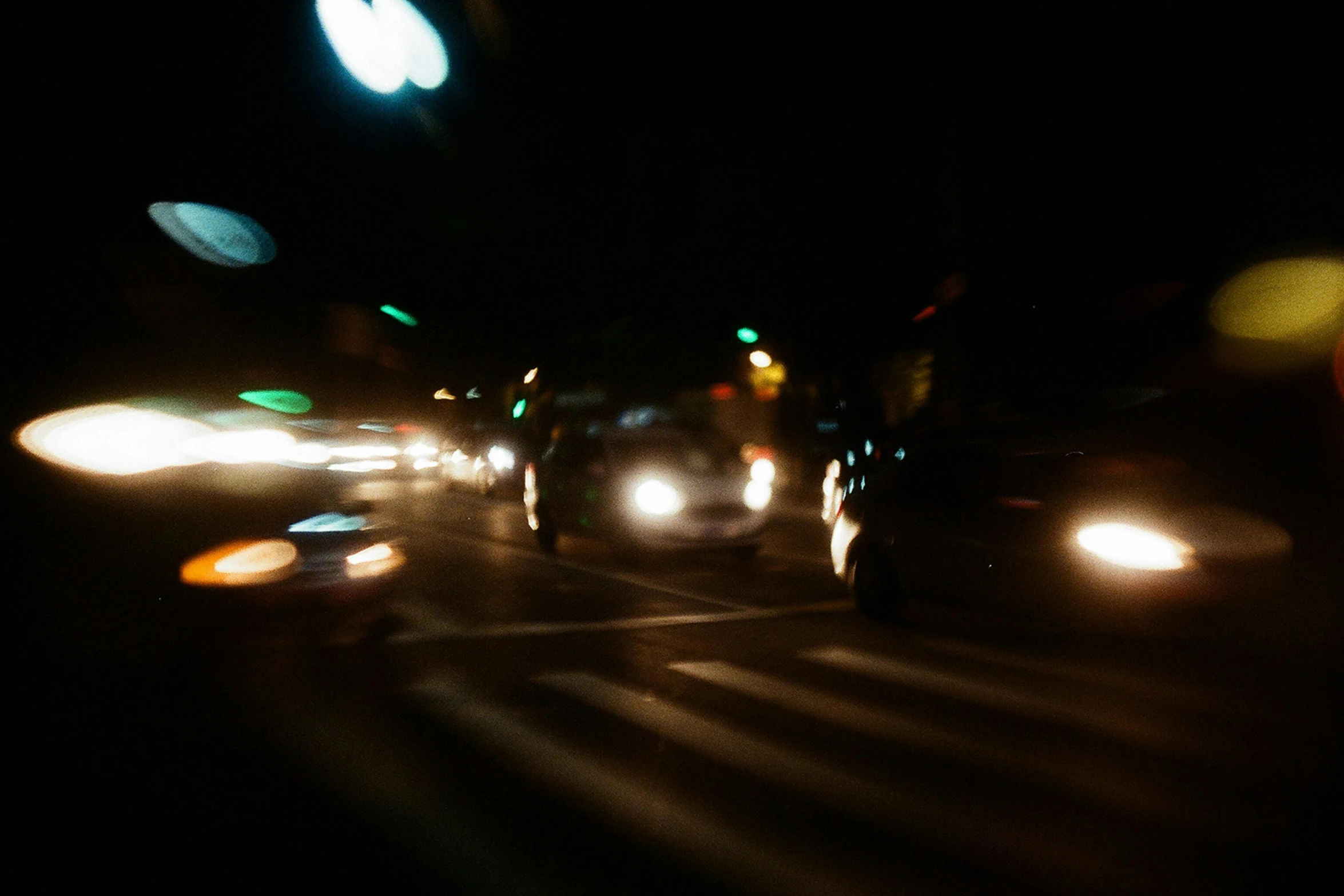 a group of cars driving down a street at night, a picture, close - up photograph, brett amory, digital photo