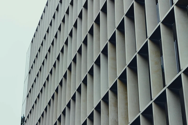 a clock mounted to the side of a building, inspired by David Chipperfield, pexels contest winner, brutalism, metal shaded, square lines, grainy photograph, grey