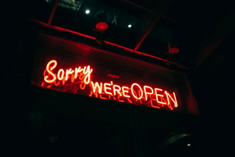 a neon sign that says sorry we're open, pexels, happening, 💋 💄 👠 👗, worthless, brandon woelfel, unbothered