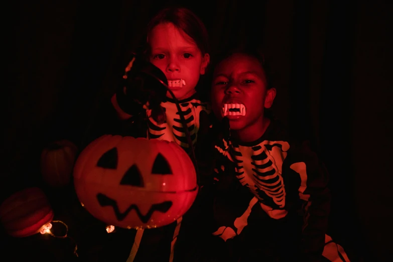 a couple of kids sitting next to each other, vanitas, holding a jack - o - lantern, screaming at the camera, dark-skinned, profile image