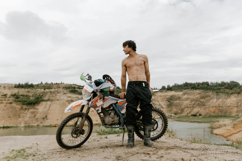 a shirtless man standing next to a dirt bike, pexels contest winner, figuration libre, 2 3 years old, avatar image, wearing cargo pants, sports photo