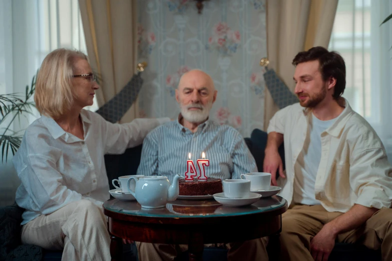 a group of people sitting around a table with a cake, a portrait, by Adam Marczyński, pexels contest winner, portrait of an old, 3 - piece, at home, promotional image