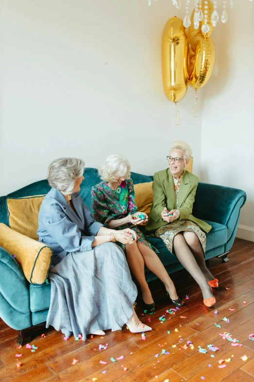 a group of women sitting on top of a couch, by Hazel Armour, pexels, modernism, holding a balloon, elderly, 3 - piece, gold