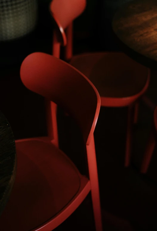 a couple of red chairs sitting next to each other, by Doug Ohlson, nightlife, depth detail, hiding, 3 colours