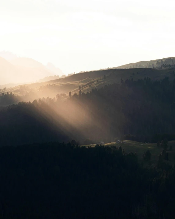 the sun shines through the trees in the mountains, a picture, unsplash contest winner, romanticism, rolling foothills, light haze, fading rainbow light, morning light showing injuries