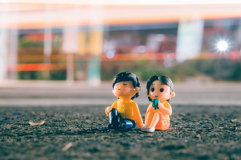 a couple of figurines sitting next to each other, unsplash, figuration libre, people waiting in bus stop, art toys on feet, snapchat photo, tiny villagers