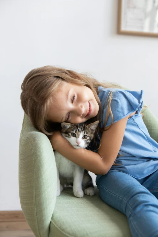 a little girl sitting in a chair with a cat, a picture, shutterstock contest winner, hugging each other, premium quality, small, a green