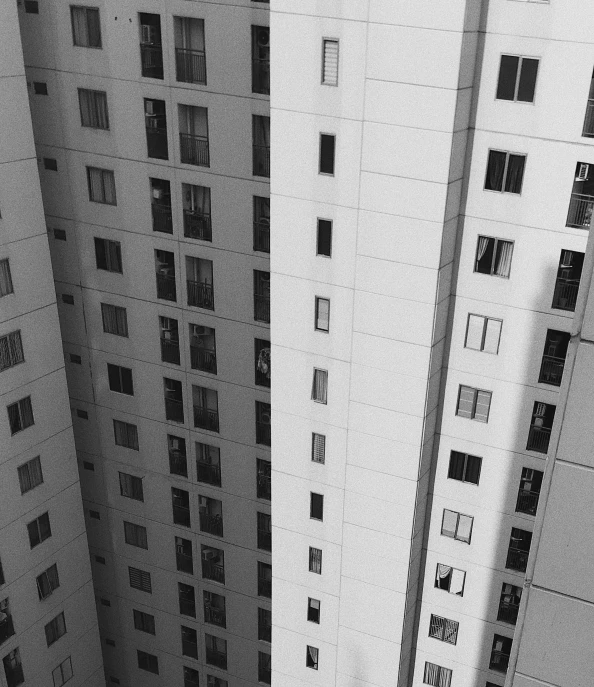 a couple of tall buildings next to each other, a black and white photo, inspired by André Kertész, unsplash, são paulo, balconies, white building, ten flats