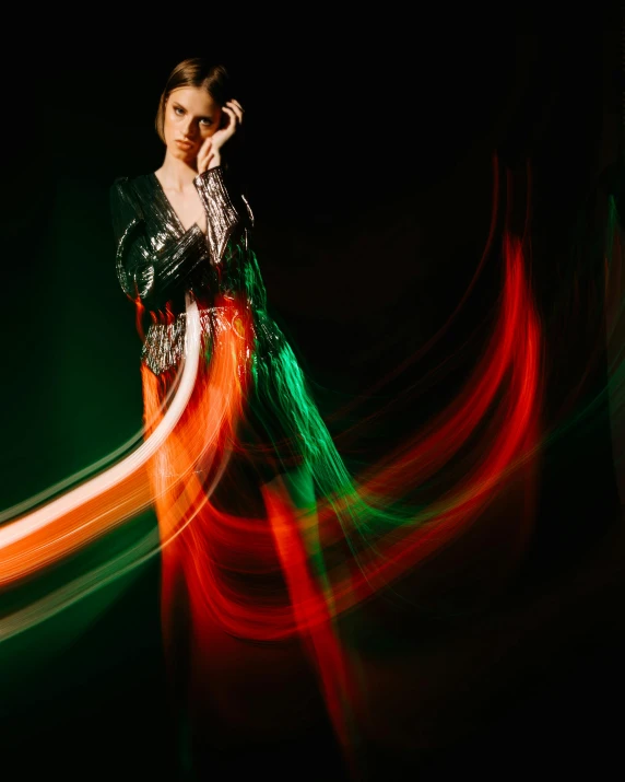 a woman holding a cell phone up to her ear, by Emma Andijewska, holography, red and green palette, flowing dress, light trail, promo image