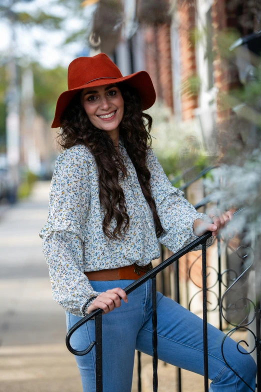 a woman in a red hat leaning on a railing, trending on reddit, wearing a blouse, wearing a cowboy hat, in savannah, liberty curls