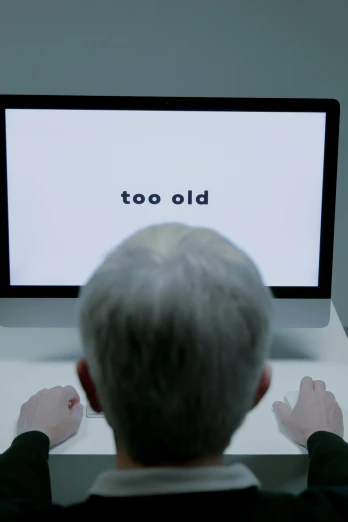 a man sitting in front of a laptop computer, inspired by Ian Hamilton Finlay, video art, old gray hair, sign that says 1 0 0, looking old, close up to the screen