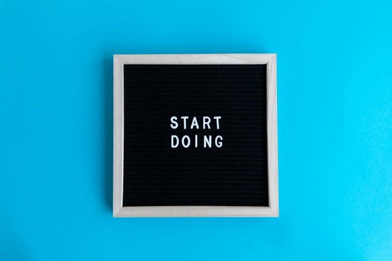 a black board with the words start doing written on it, trending on unsplash, with a blue background, lightbox, no text, front facing
