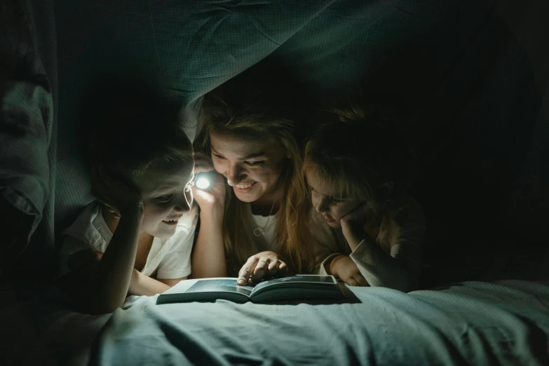 two girls reading a book under the covers of a bed, a portrait, pexels contest winner, holding up a night lamp, 3 sisters look into the mirror, avatar image, flashlight on