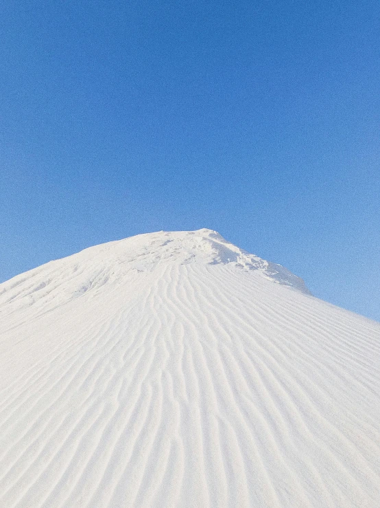 a man riding a snowboard down a snow covered slope, inspired by Scarlett Hooft Graafland, trending on unsplash, sand texture, pyramid, covered in white flour, in the desert beside the gulf