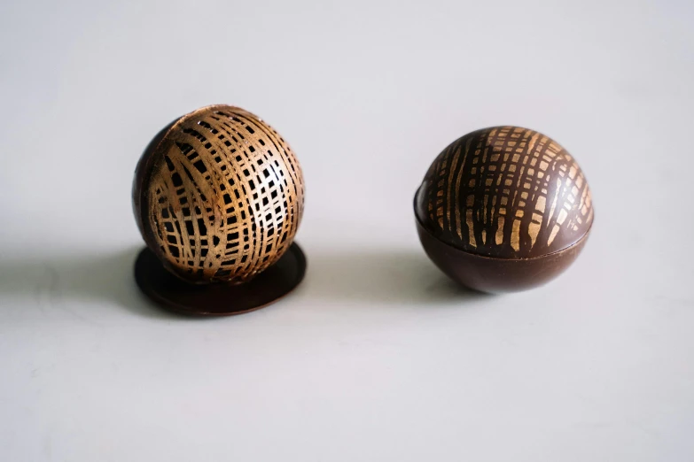 a couple of wooden balls sitting on top of a table, inspired by Károly Markó the Elder, unsplash, mingei, chocolate candy bar packaging, wood burn, 1790, intricate latex set