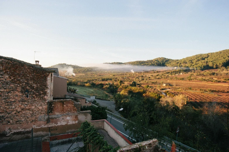 a view of the countryside from the top of a hill, inspired by Matteo Pérez, happening, conde nast traveler photo, mist below buildings, traditional corsican, at the golden hour